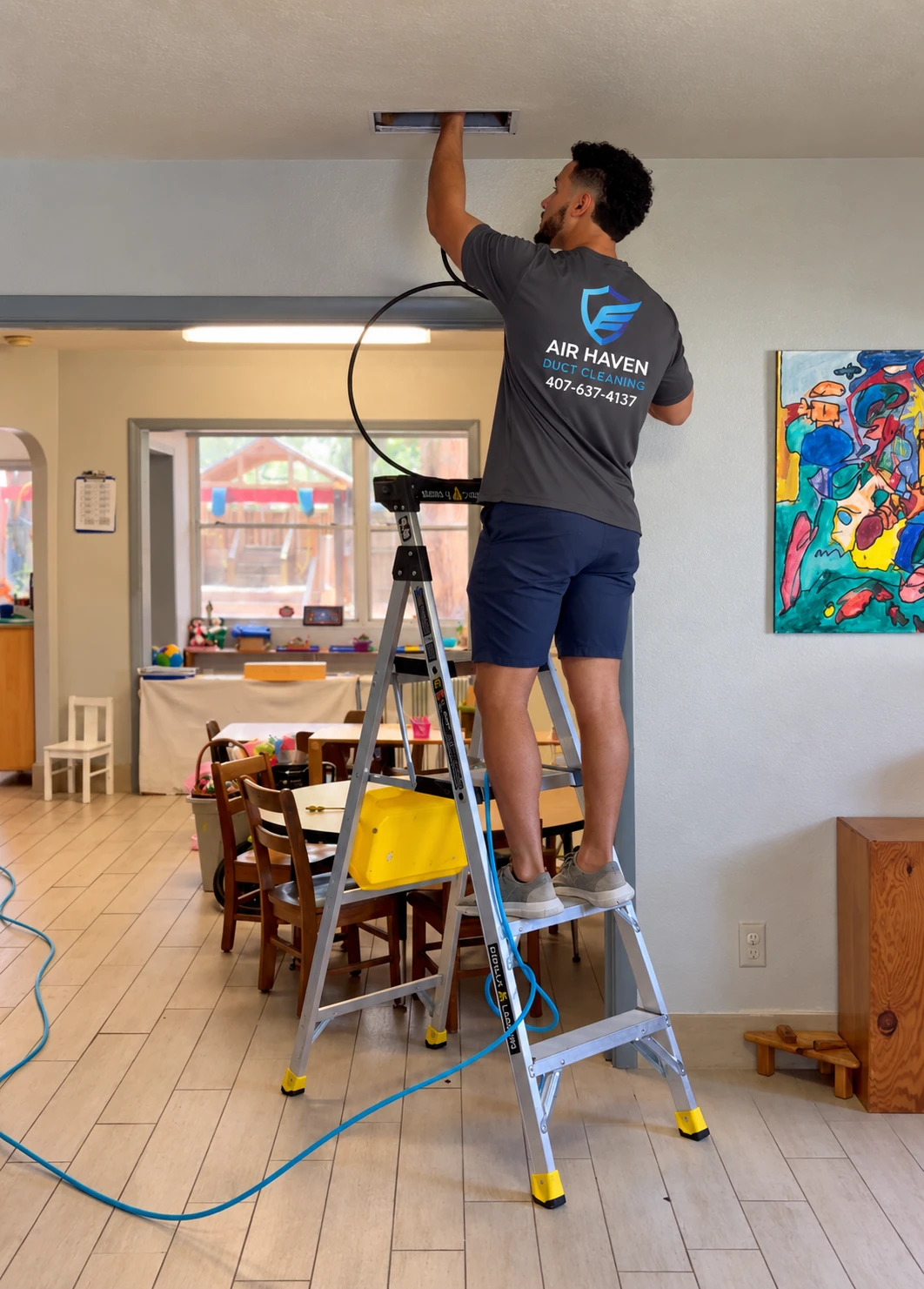 Air Haven technician on a ladder cleaning a ceiling air vent